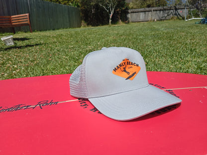 Grey trucker cap on surfboard.